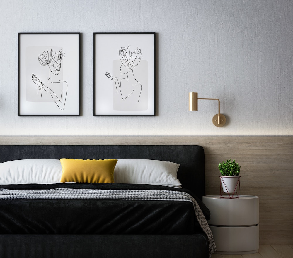 minimal bedroom with artwork, bed, and lamp